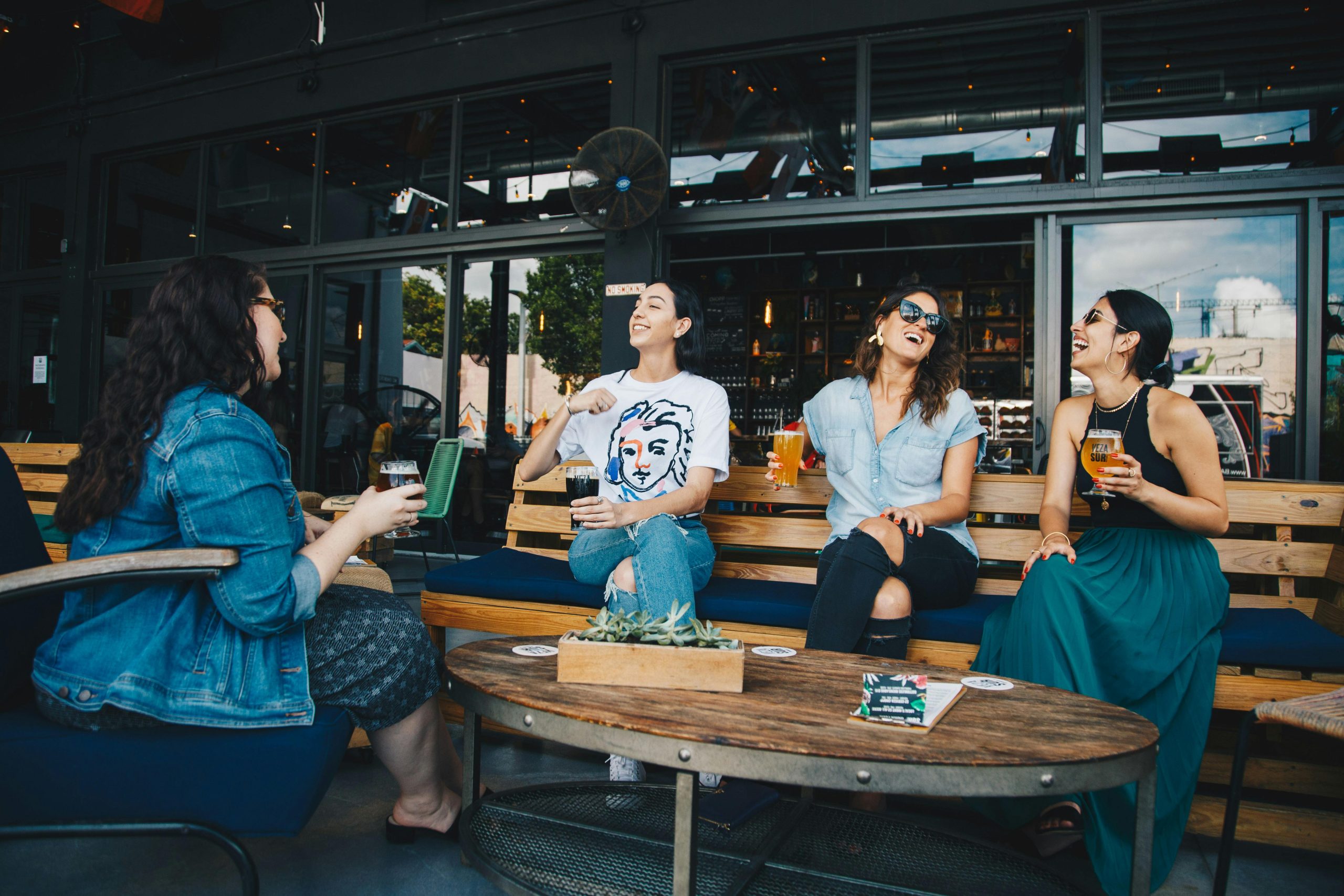 group of people sitting in a terrace by a restaurant, drinking, chatting and laughing